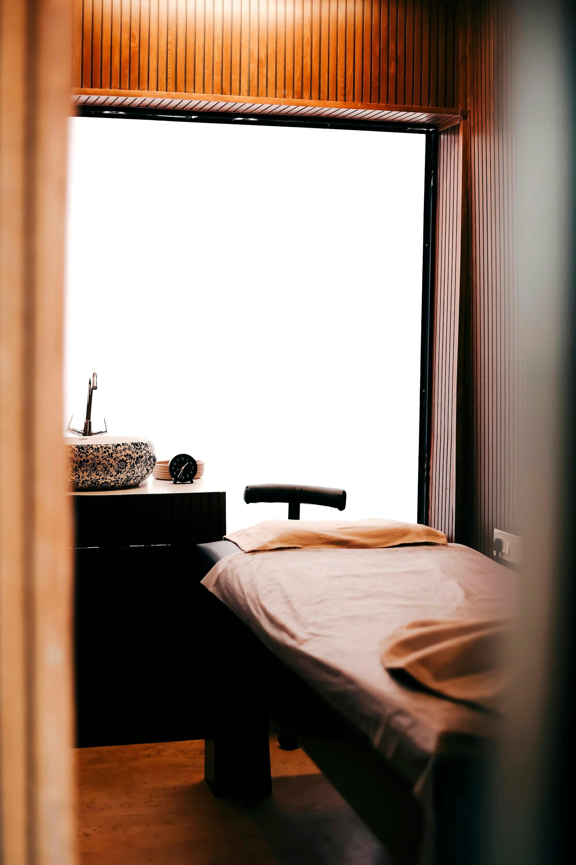 Calm treatment room with a neutral-toned treatment bed